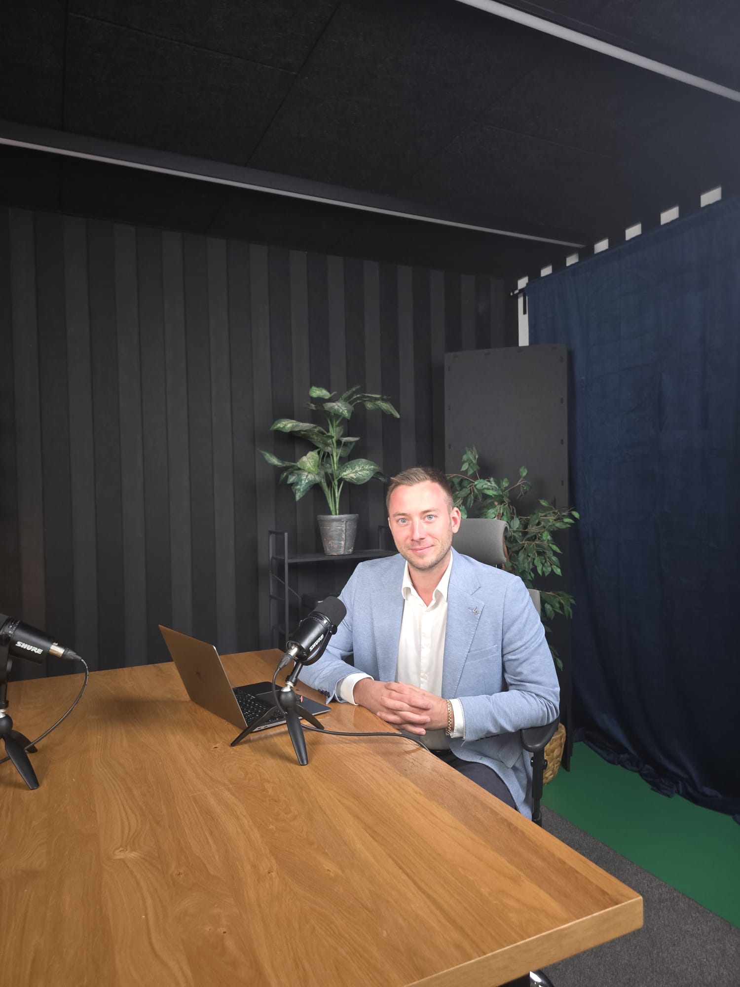 Maciej Korzewa przy mikrofonie w studiu nagraniowym